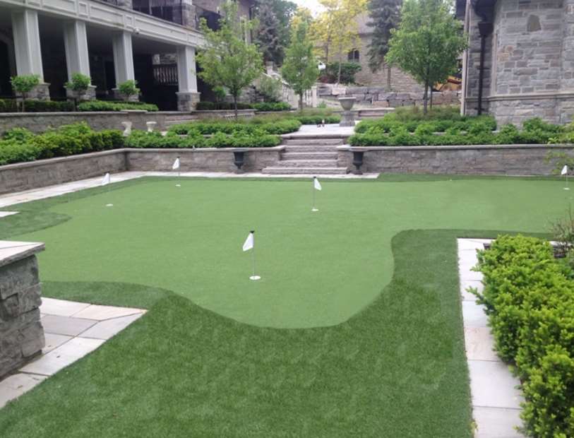 Palm surrounded by artificial grass and curbed blocks